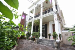 a white house with potted plants on the stairs at Fleur De Lis Mansion in New Orleans