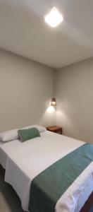 une chambre avec un grand lit blanc avec une couverture verte dans l'établissement Ayamar Kite House - Apto Superior, à Cruz