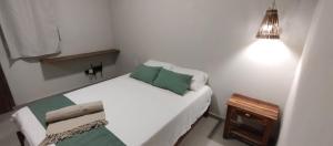 - un lit blanc avec des oreillers verts dans l'établissement Ayamar Kite House - Apto Superior, à Cruz