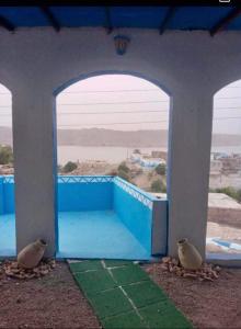 two birds sitting in an archway with a view at Asilah kato nubian guest house in Aswan