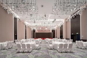 a banquet hall with white tables and chairs and chandeliers at Holiday Inn Taiyuan Sunshine by IHG in Taiyuan