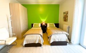 マテーラにあるFitta Camere Materaの緑の壁の部屋(ベッド2台付)
