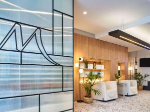 a lobby with a view of the ocean through a glass wall at Mercure Paris 15 Porte de Versailles in Paris