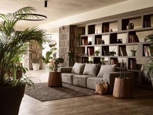 a living room with a couch and lots of plants at Numo Ierapetra Beach Resort Crete, Curio Collection Hilton in Ierápetra