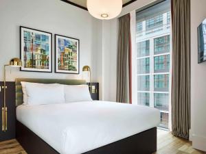 a bedroom with a bed and a large window at TRIBE London Canary Wharf in London