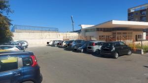 Une rangée de voitures garées sur un parking dans l'établissement Fitta Camere Matera, à Matera