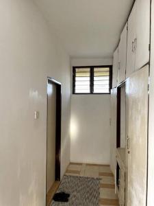 an empty room with a hallway with a window at Mintari Penthouse, Nyali. in Mombasa
