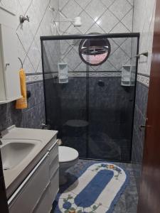 uma casa de banho com um chuveiro, um WC e um lavatório. em Hostel do Enzo em Itanhaém