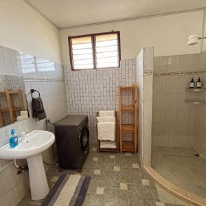 a bathroom with a sink and a shower at Mintari Penthouse, Nyali. in Mombasa