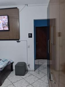 a room with a sliding glass door and a tv at Hostel do Enzo in Itanhaém