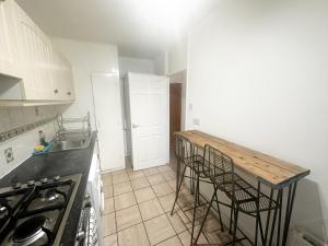 a kitchen with a counter top and chairs in it at Aldgate flats in London