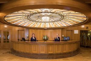 three people standing at a reception desk in a lobby at htop Amaika & SPA 4Sup - Adults Only #htopBliss in Calella