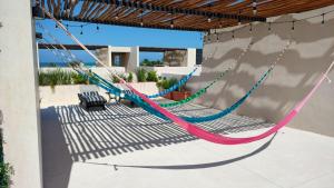 a hammock on the side of a patio at Chicxulub hermoso in Chicxulub