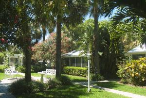 a park with two park benches and palm trees at Cottages by the Ocean in Pompano Beach