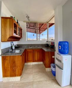 a kitchen with a sink and a refrigerator at Suite “Raya” in Puerto Ayora