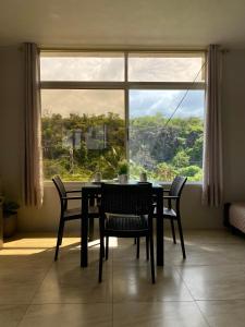 uma mesa de jantar com cadeiras em frente a uma janela em Suite “Raya” em Puerto Ayora