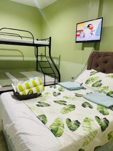 um quarto com uma cama com uma colcha com folhas em Flavioso em Catarman
