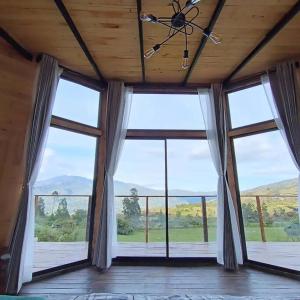 a large room with large windows with a view at Glamping Caelum. Refugio al aire libre, en Macheta Cundinamarca in Machetá