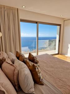 a bedroom with a large bed with a large window at Lê Maison Deluxe Madeira in Ponta do Sol