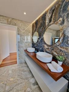 a bathroom with two sinks and a large mirror at Lê Maison Deluxe Madeira in Ponta do Sol