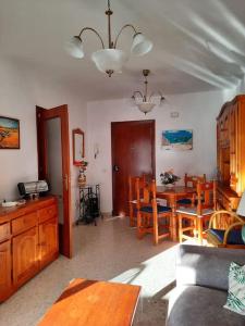 uma sala de estar com uma mesa e uma sala de jantar em Mi bonito apartamento del Portil em El Portil