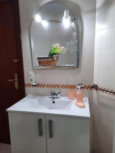 y baño con lavabo blanco y espejo. en Mi bonito apartamento del Portil, en El Portil