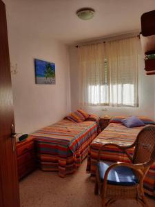 um quarto de hotel com duas camas e uma janela em Mi bonito apartamento del Portil em El Portil