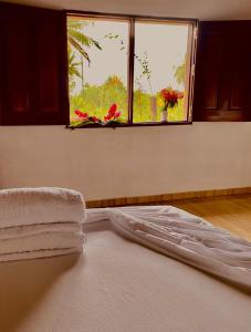 a bed with towels on it in a room with a window at Cabañas Iracas del Mar in Nuquí