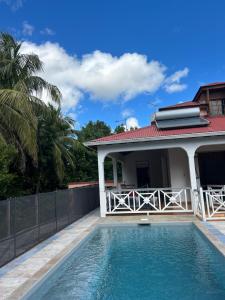 eine Villa mit Swimmingpool vor einem Haus in der Unterkunft L’Amandine in Sainte-Anne