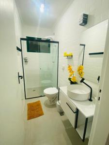 een witte badkamer met een douche en een toilet bij Apartamento beira mar vista para montanha em Massaguaçú in Caraguatatuba