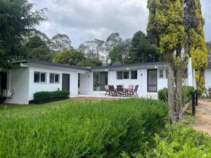 una casa blanca con mesas y sillas en el patio en Silverhill Cottage, en Exeter