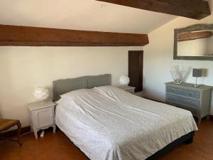 FlayoscにあるHoliday Home in Flayosc with Pool and Terraceのベッドルーム1室(ベッド1台、テーブル2台、鏡付)