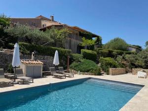 FlayoscにあるQuaint Villa with Private Pool in Flayosc Franceの家の隣のプール(椅子、パラソル付)