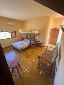 カノア・ケブラーダにあるPousada Akronosのベッド1台、椅子、ベンチが備わる客室です。