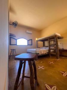 Pokój z 2 łóżkami piętrowymi i stołem w obiekcie Pousada Akronos w mieście Canoa Quebrada