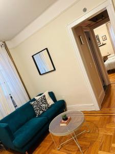 a living room with a blue couch and a table at SUNNYside one bedroom apt in Woodside