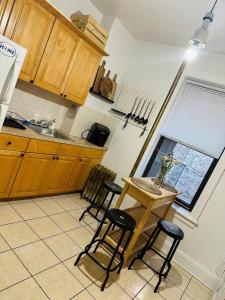 cocina con mesa, sillas y fregadero en SUNNYside one bedroom apt, en Woodside