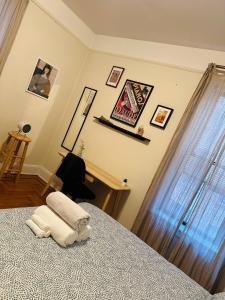 WoodsideにあるSUNNYside one bedroom aptのベッドルーム1室(ベッド1台付)が備わります。壁には絵画が飾られています。