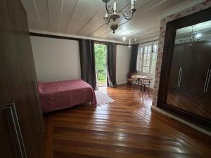 a bedroom with a bed and a table in a room at Casa Temporada recanto de minas in Tiradentes