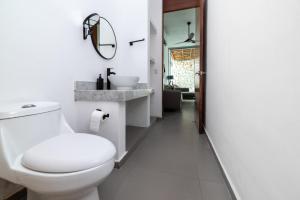 un bagno bianco con un water e un lavandino di Relaxing 2 bedroom apartement in the center of tulum with private pool and terrace a Tulum Altre 5 foto