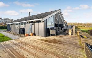 uma casa com um deque de madeira com um telhado inclinado em Nice Home In Sjlund With Sauna em Sjølund