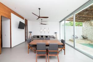 una sala da pranzo con tavolo e sedie di Relaxing 2 bedroom apartement in the center of tulum with private pool and terrace a Tulum
