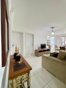 un salon avec un canapé et une table dans l'établissement APARTAMENTO à 100 m do mar (1 min a pé), à Bombinhas 8 autres photos