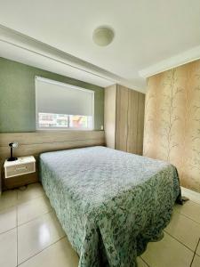 une chambre avec un lit et une fenêtre dans l'établissement APARTAMENTO à 100 m do mar (1 min a pé), à Bombinhas