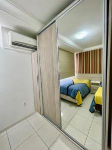 une chambre avec un lit et une porte coulissante en verre dans l'établissement APARTAMENTO à 100 m do mar (1 min a pé), à Bombinhas