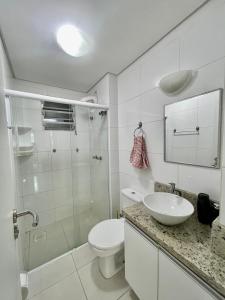 une salle de bain avec toilettes, lavabo et douche dans l'établissement APARTAMENTO à 100 m do mar (1 min a pé), à Bombinhas