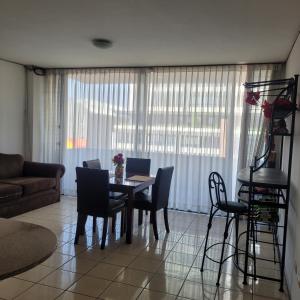uma sala de estar com uma mesa de jantar e cadeiras em apartamento 407 zona 9 em Guatemala