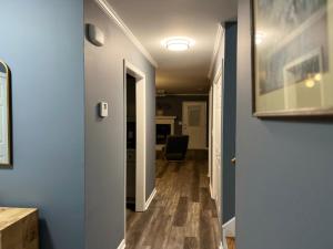 a hallway with blue walls and a room with a chair at Cozy Entire Home 9 min from RAFB w Large Bedrooms in Warner Robins