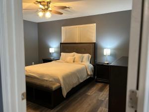 een slaapkamer met een bed, een plafondventilator en 2 lampen bij Cozy Entire Home 9 min from RAFB w Large Bedrooms in Warner Robins