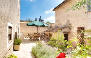 eine Außenterrasse mit einem Tisch und einem Sonnenschirm in der Unterkunft Le Jardin du Village - Valbonne in Valbonne